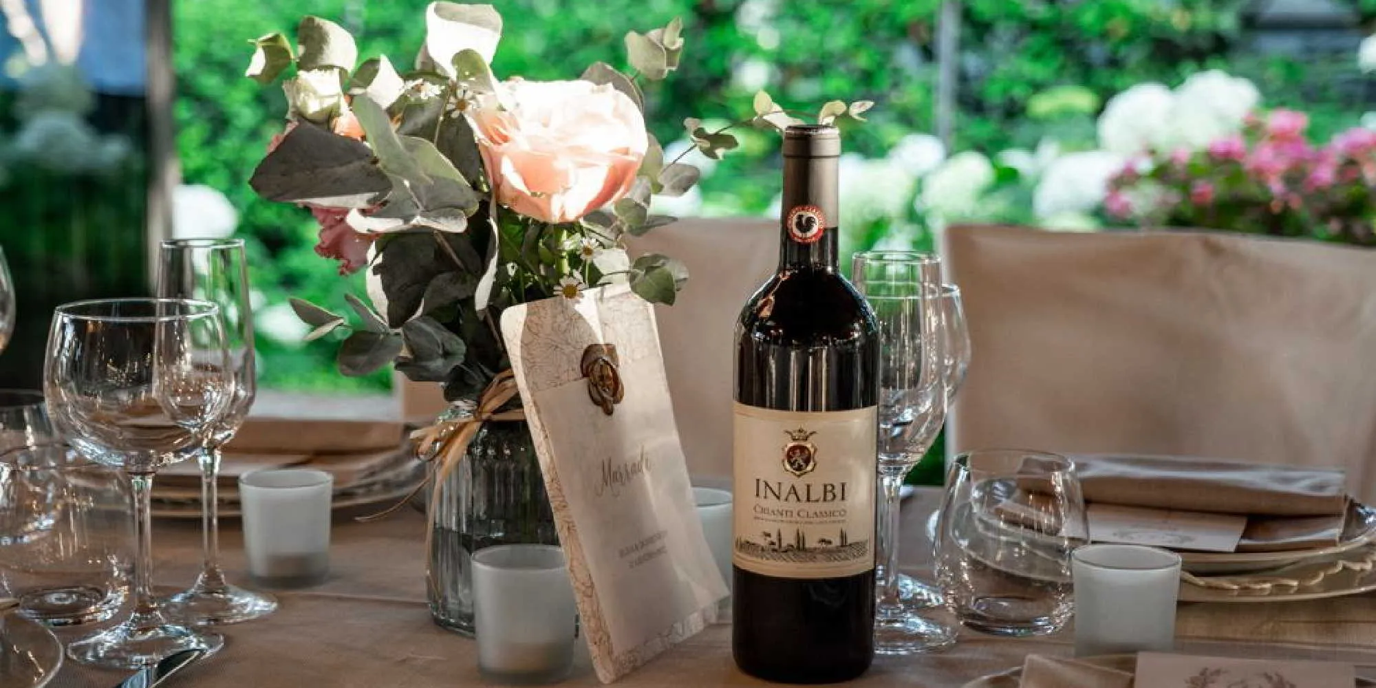 Tavolo allestito all'aperto con una bottiglia di Chianti Classico Inalbi