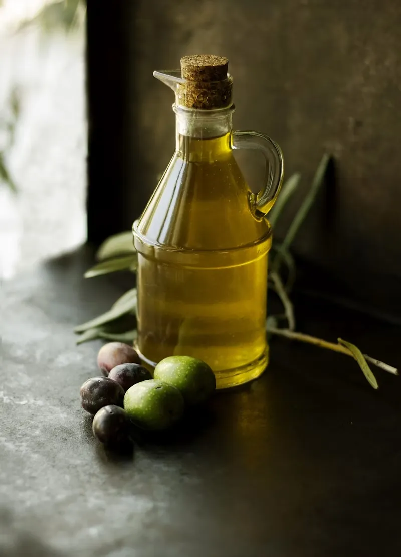 Oliera con il nostro olio extra vergine, olive fresche e un ramoscello d'ulivo